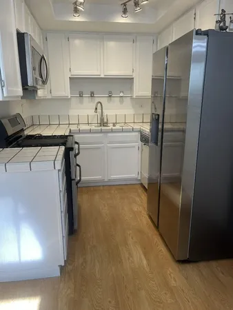 a kitchen with a sink a refrigerator and cabinets