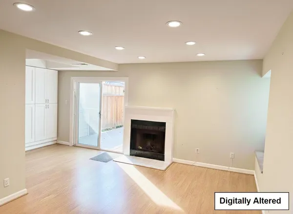 an entryway and an empty room with wooden floor