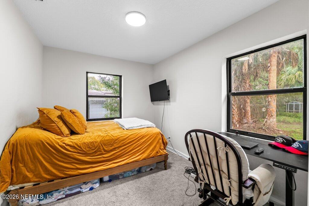 1138 Halifax Road Jacksonville, FL 32216 - Photo 19 of 34 a bedroom with a bed and flat screen tv