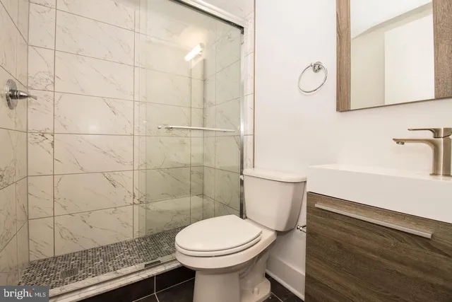 a bathroom with a sink a toilet and a mirror