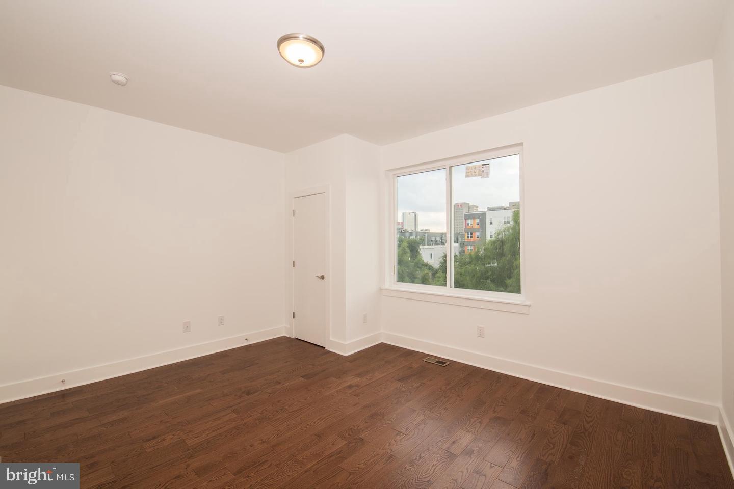 1956 North 8th Street, Unit 2 Philadelphia, PA 19122 - Photo 14 of 23 an empty room with wooden floor and windows
