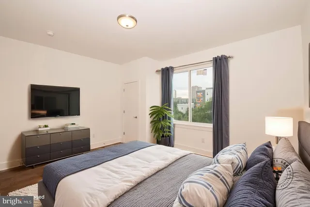 a bedroom with a bed and a flat screen tv