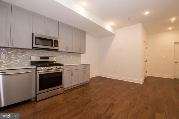 a kitchen with granite countertop a sink and steel appliances