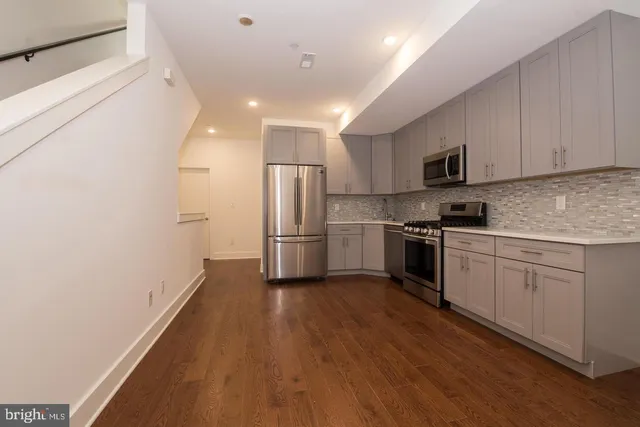 a kitchen with refrigerator a microwave and white cabinets