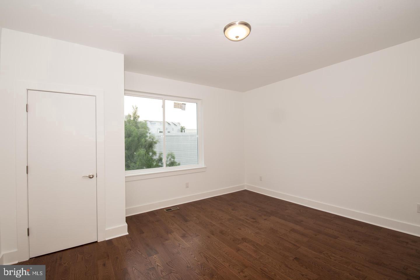1956 North 8th Street, Unit 2 Philadelphia, PA 19122 - Photo 8 of 23 an empty room with wooden floor and windows