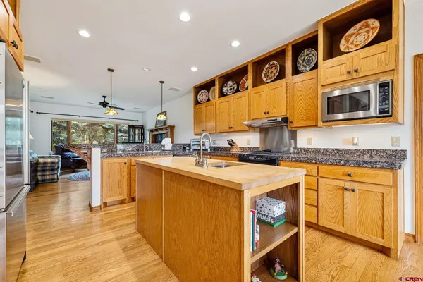 a kitchen with stainless steel appliances granite countertop a stove a sink and a refrigerator