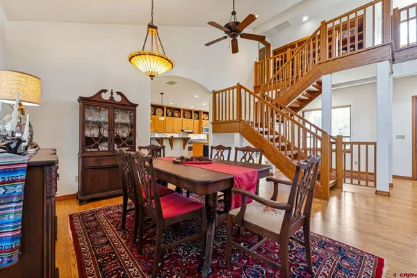 a dining room with wooden floor a chandelier a wooden table and chairs