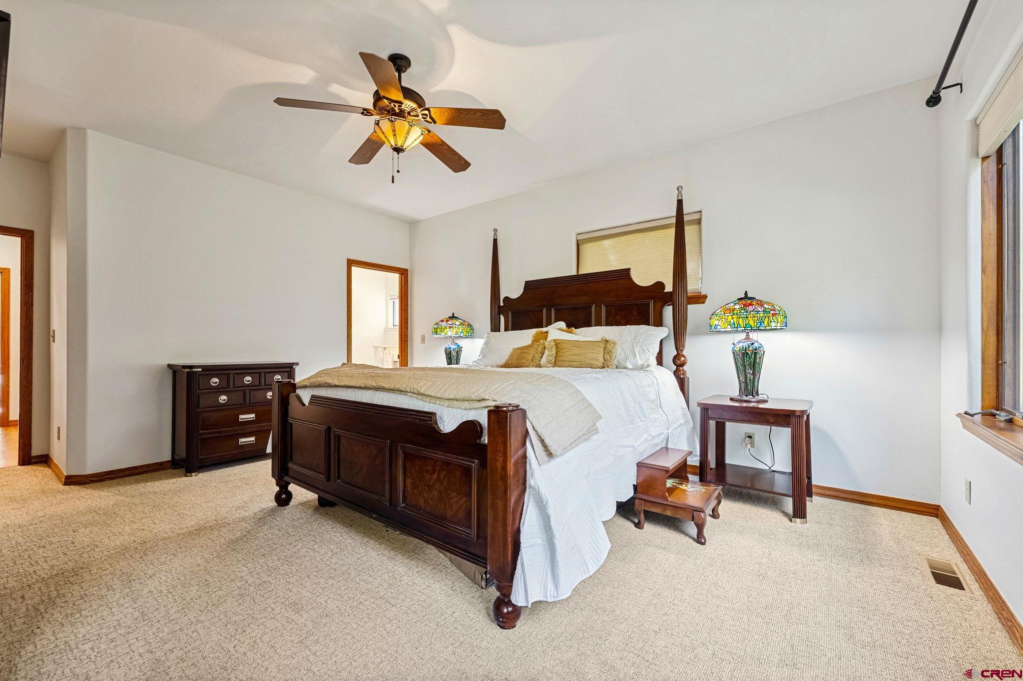 345 Red Rock Road Durango, CO 81301 - Photo 20 of 44 a bedroom with a bed a chandelier and dresser