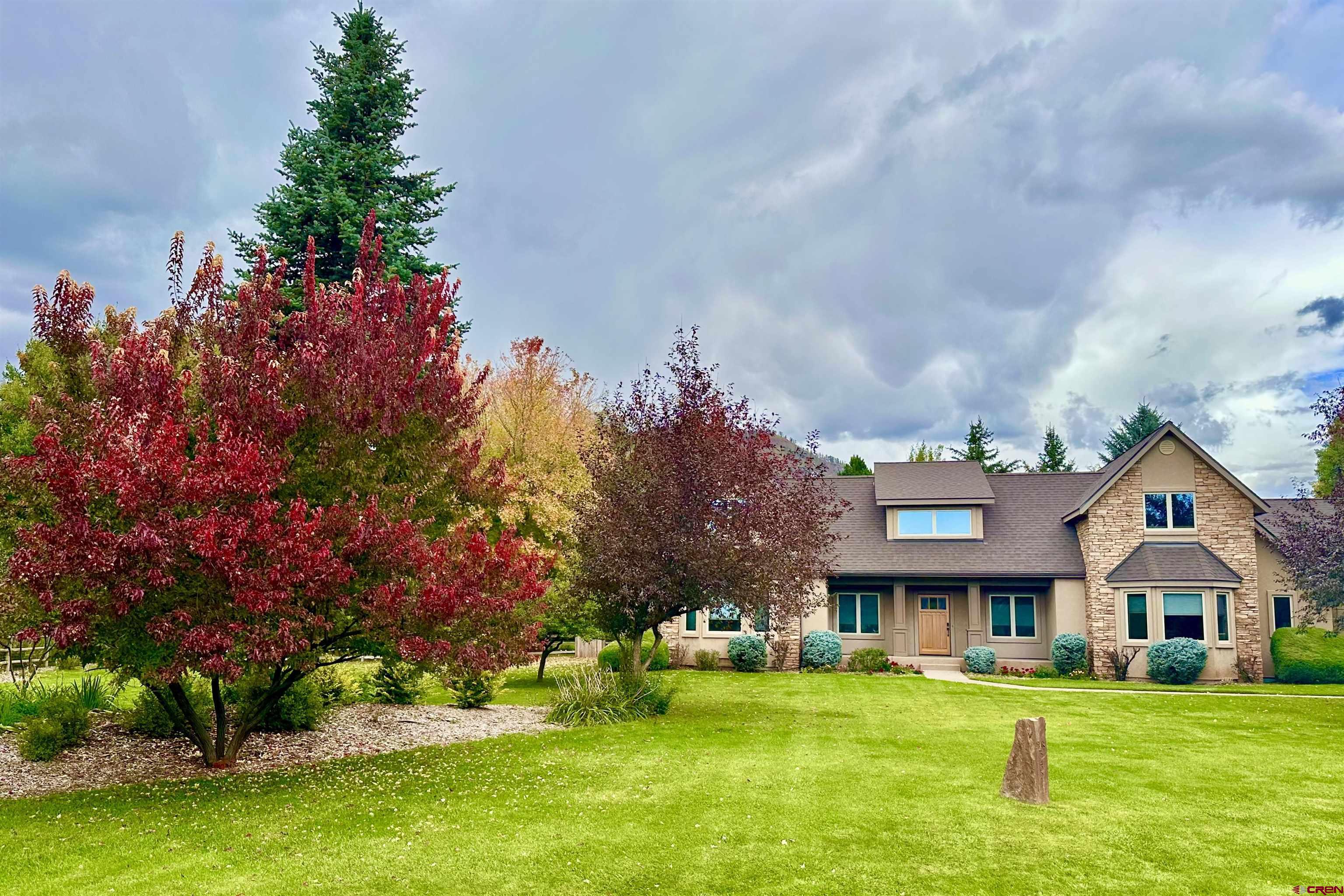 345 Red Rock Road Durango, CO 81301 - Photo 2 of 44 a front view of a house with a garden