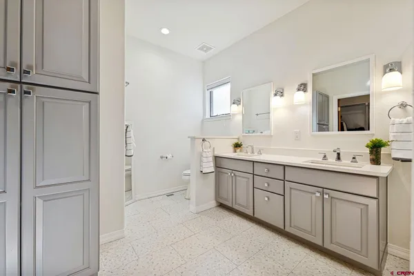 a spacious bathroom with a double vanity sink a mirror and a