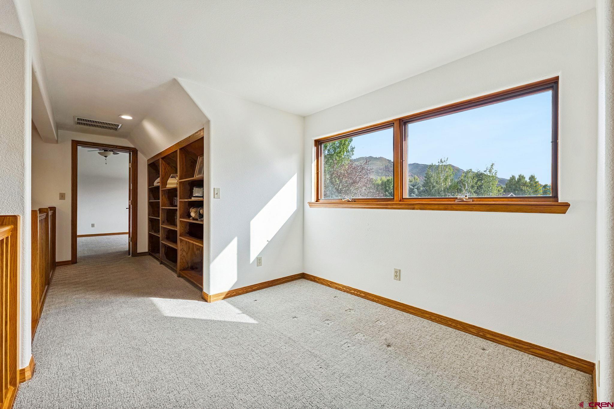 345 Red Rock Road Durango, CO 81301 - Photo 32 of 44 an empty room with a window and a kitchen