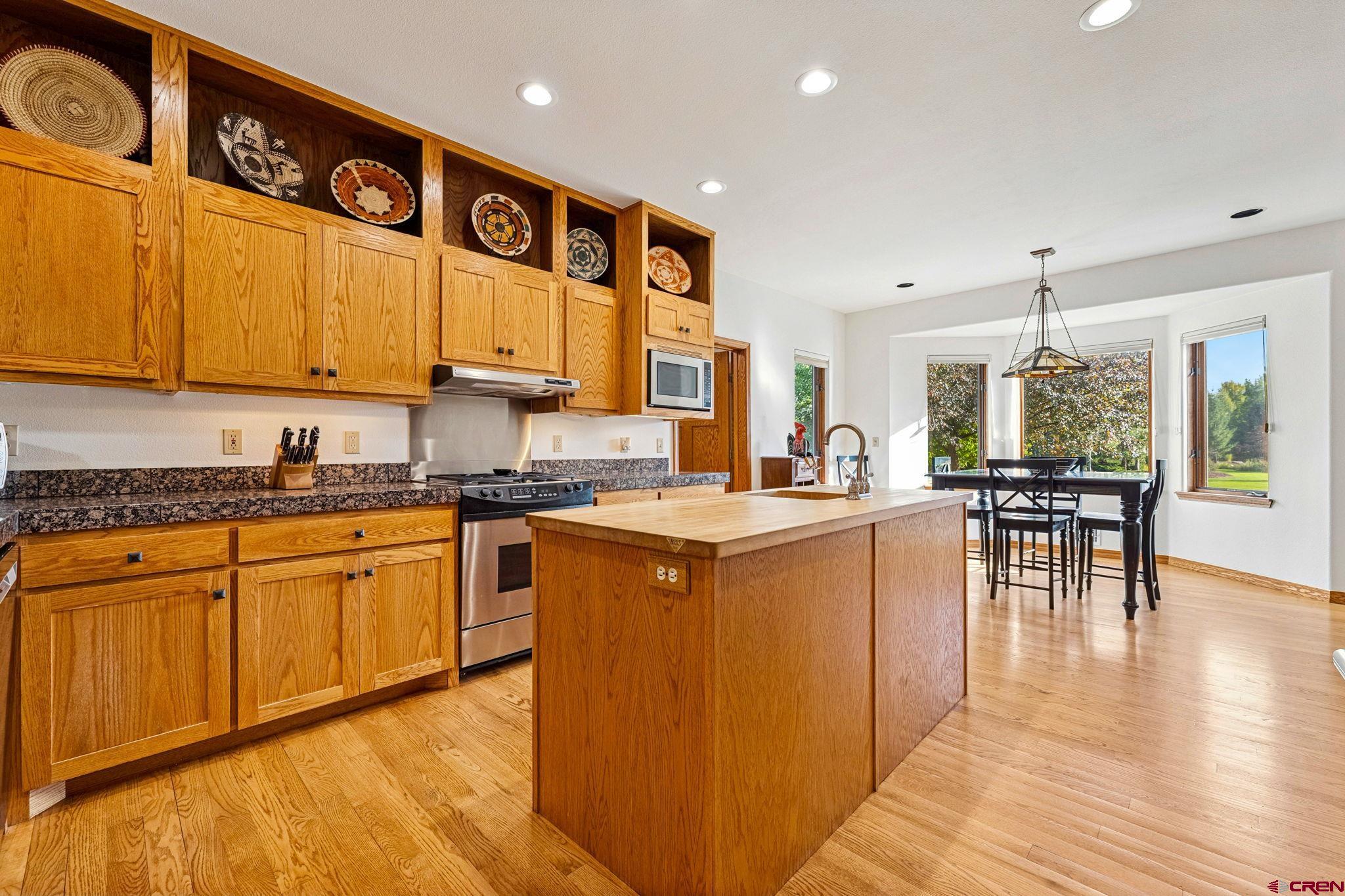 345 Red Rock Road Durango, CO 81301 - Photo 8 of 44 a kitchen with stainless steel appliances granite countertop wooden cabinets a sink and dishwasher a stove with wooden floor