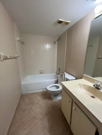 a bathroom with a granite countertop sink a toilet and bathtub