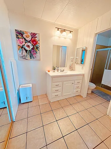a spacious bathroom with a sink a vanity and a mirror