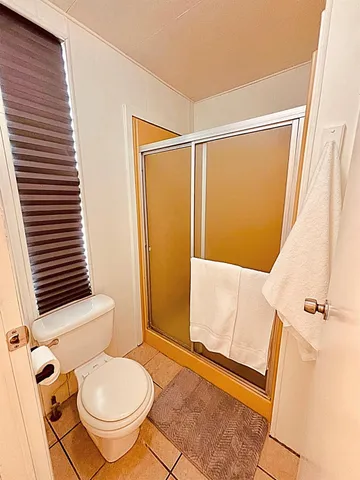 a bathroom with a granite countertop shower and a toilet