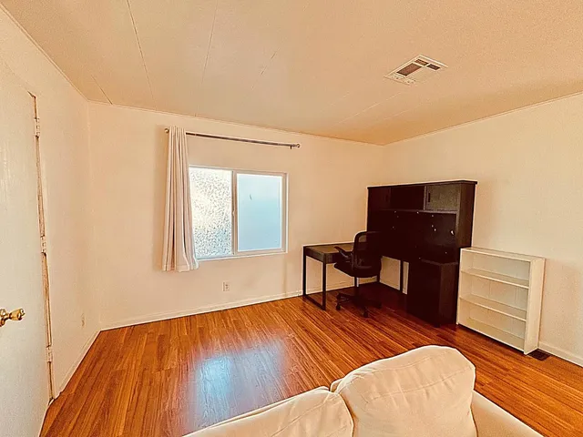 a workspace room with furniture and wooden floor
