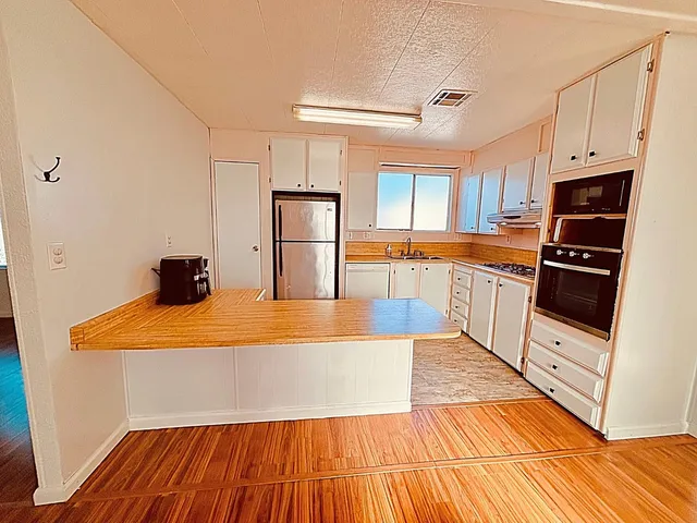 a large kitchen with cabinets and stainless steel appliances