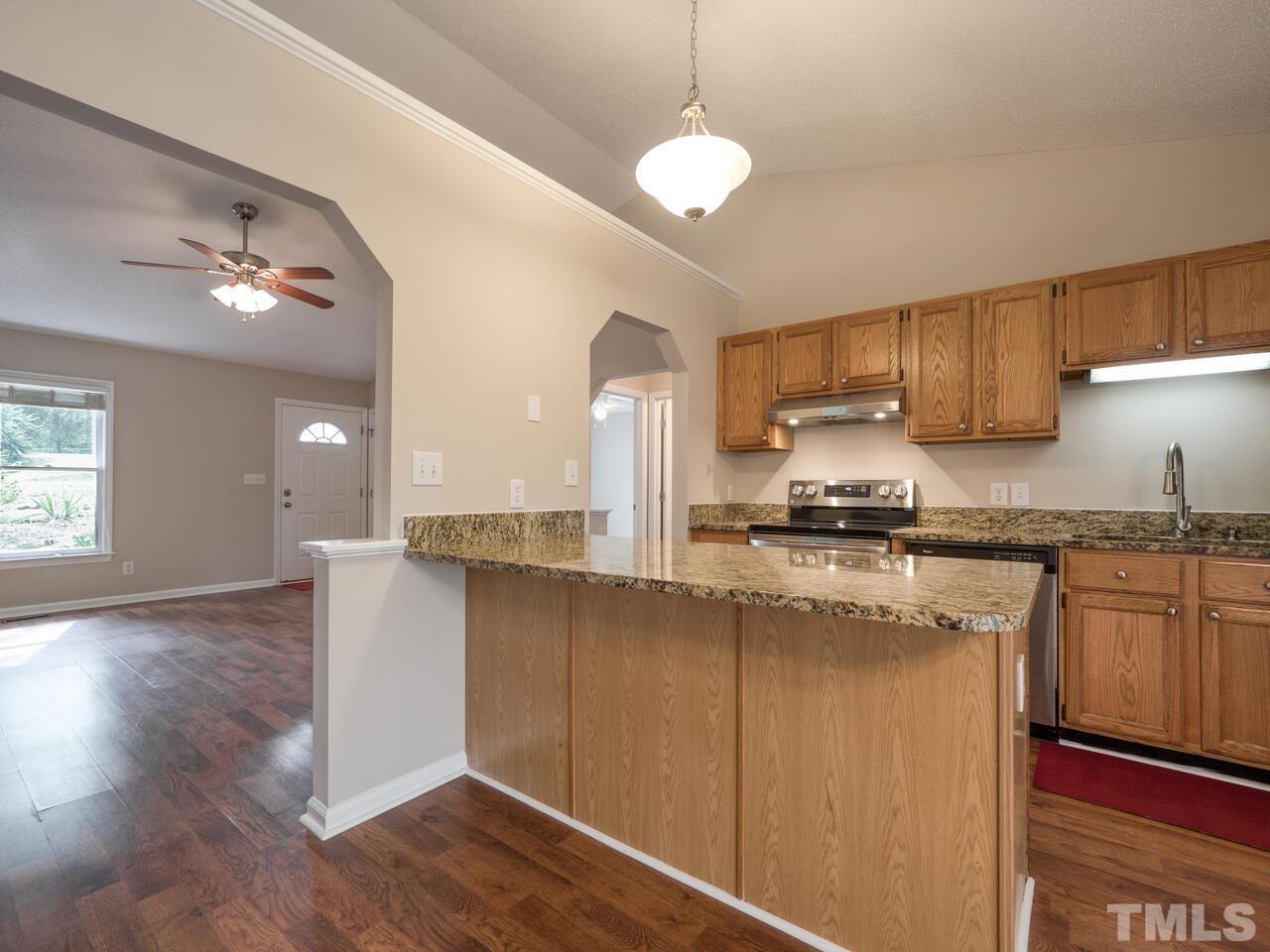 745 Brewer Circle Wake Forest, NC 27587 - Photo 13 of 43 a kitchen with stainless steel appliances granite countertop a sink a stove a refrigerator cabinets and wooden floor