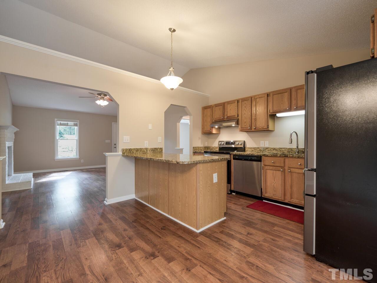 745 Brewer Circle Wake Forest, NC 27587 - Photo 16 of 43 a kitchen with granite countertop wooden floors stainless steel appliances a sink and a window