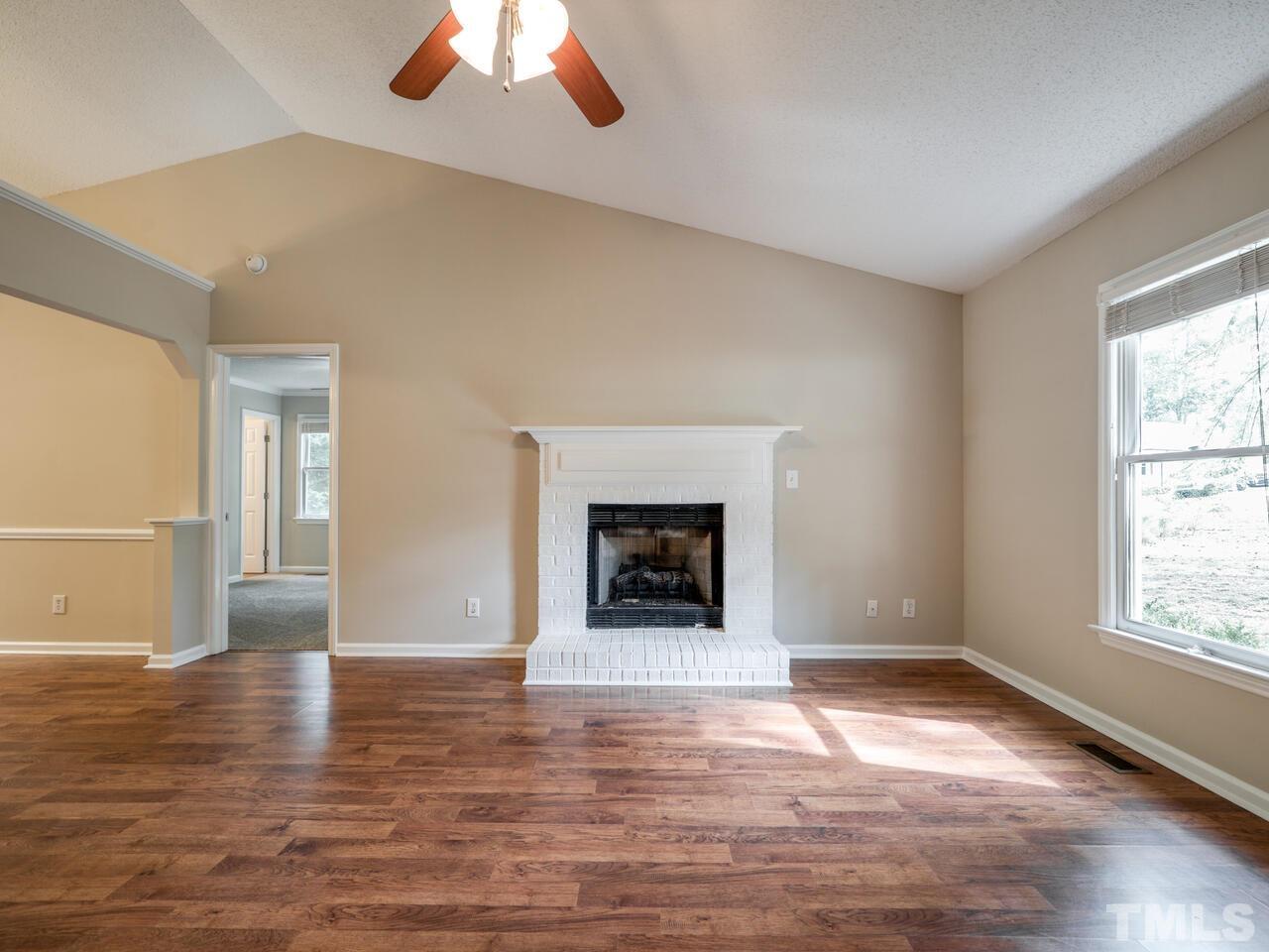 745 Brewer Circle Wake Forest, NC 27587 - Photo 10 of 43 an empty room with wooden floor windows and fireplace
