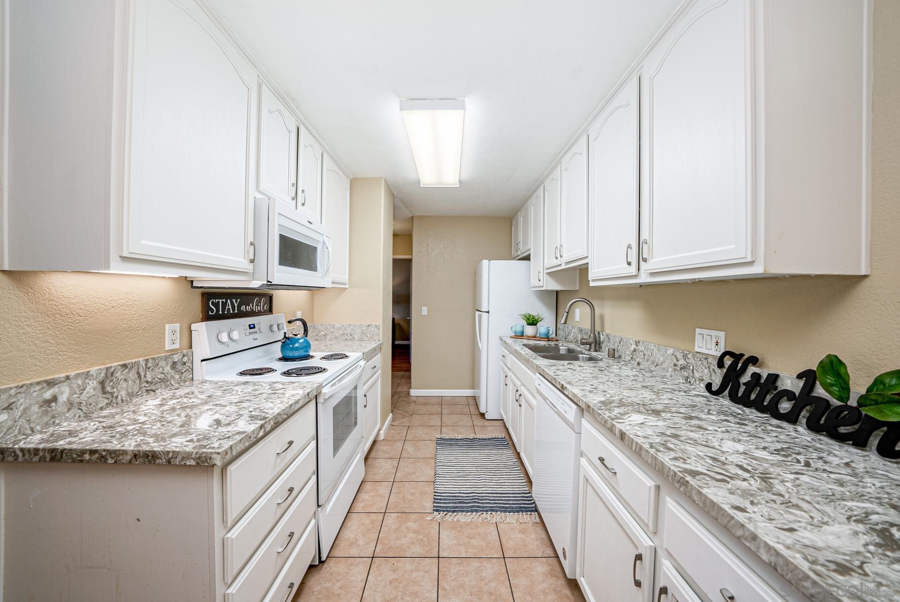 a kitchen with granite countertop stainless steel appliances lots of counter top space sink stove and cabinets