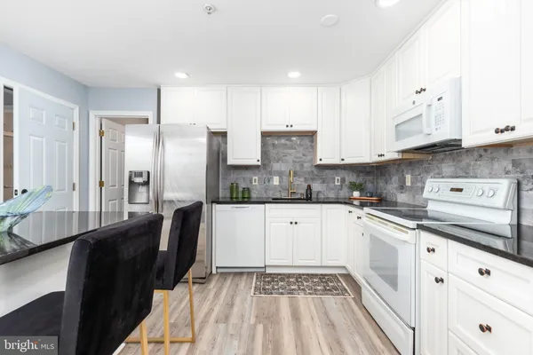a kitchen with stainless steel appliances granite countertop a refrigerator sink and cabinets