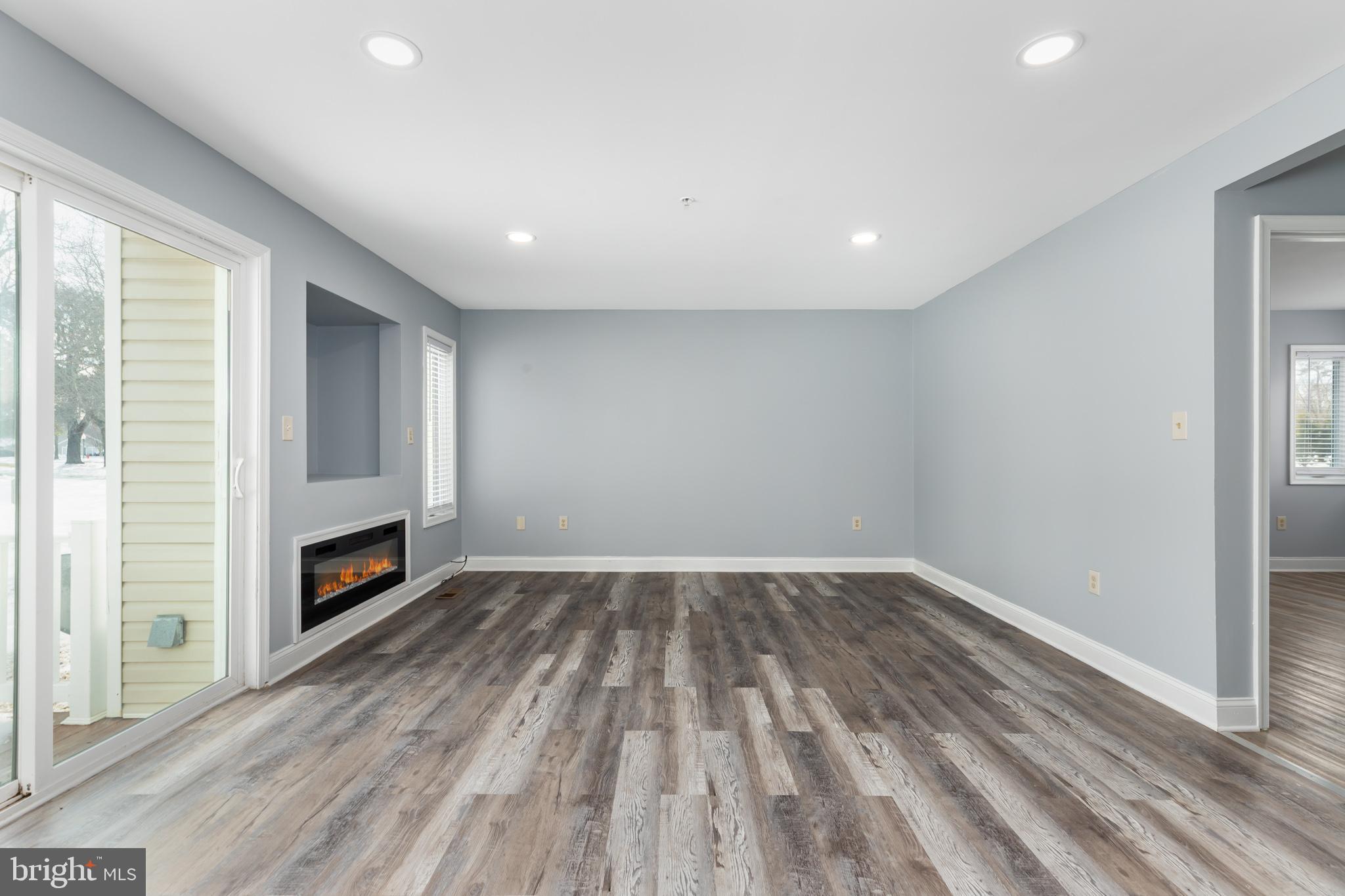 11602 Masters Lane, Unit 120 Berlin, MD 21811 - Photo 9 of 29 a view of main area fire place window and wooden floor