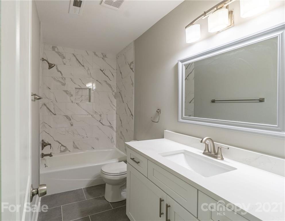 721 Rome Court Charlotte, NC 28209 - Photo 17 of 21 a bathroom with a granite countertop sink a toilet and bathtub
