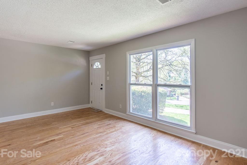 721 Rome Court Charlotte, NC 28209 - Photo 4 of 21 a view of an empty room with wooden floor and a window