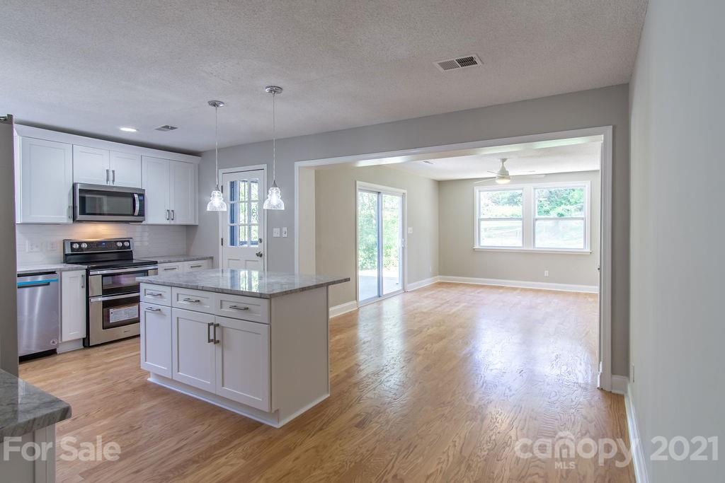 721 Rome Court Charlotte, NC 28209 - Photo 6 of 21 a kitchen with stainless steel appliances granite countertop a stove top oven a sink dishwasher a refrigerator and a oven with wooden floor
