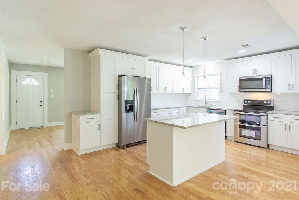 721 Rome Court Charlotte, NC 28209 - Photo 7 of 21 a kitchen with granite countertop a refrigerator and a stove top oven