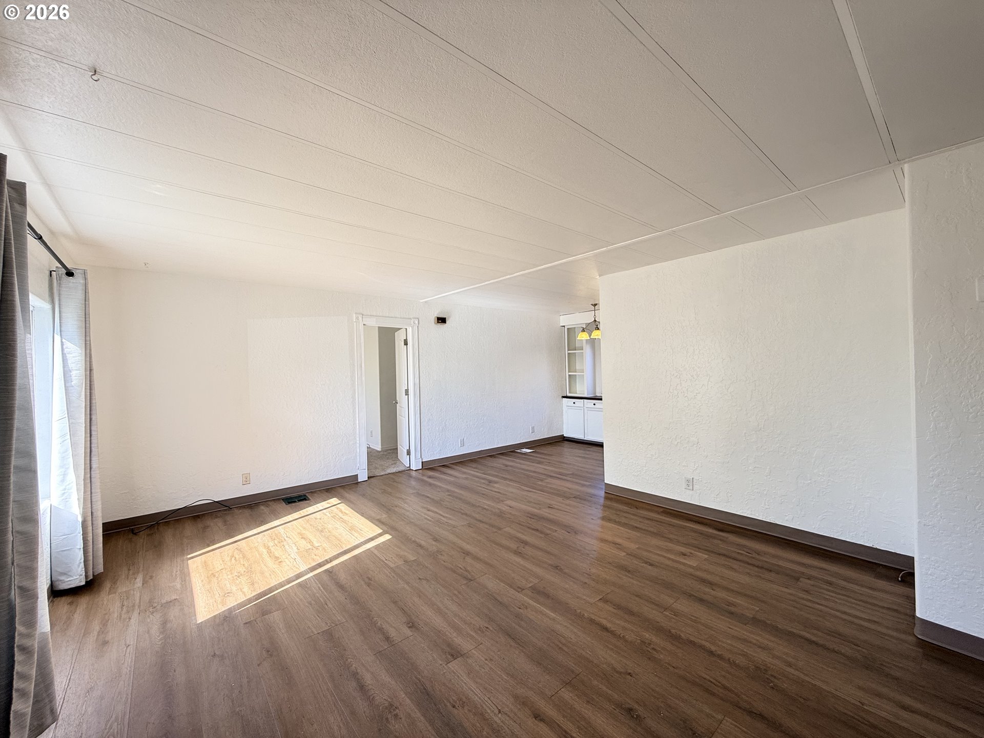 1330 West Sunland Avenue Hermiston, OR 97838 - Photo 20 of 23 an empty room with wooden floor and windows