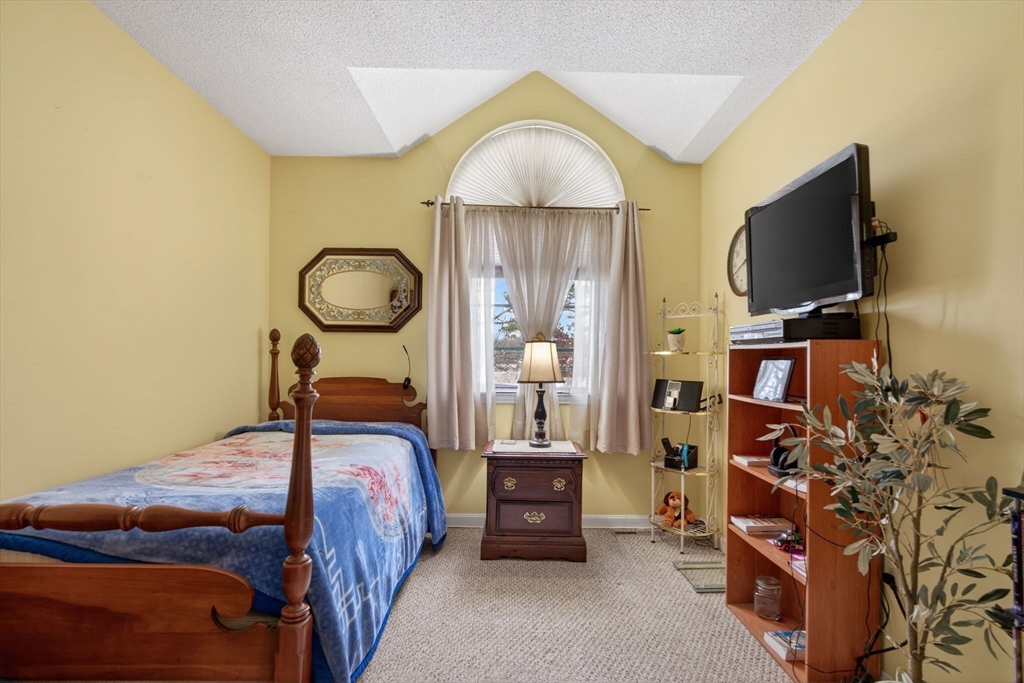 104 Johnson Road, Unit 1103 Chicopee, MA 01022 - Photo 23 of 42 a bedroom with a bed and a flat tv screen on the dresser
