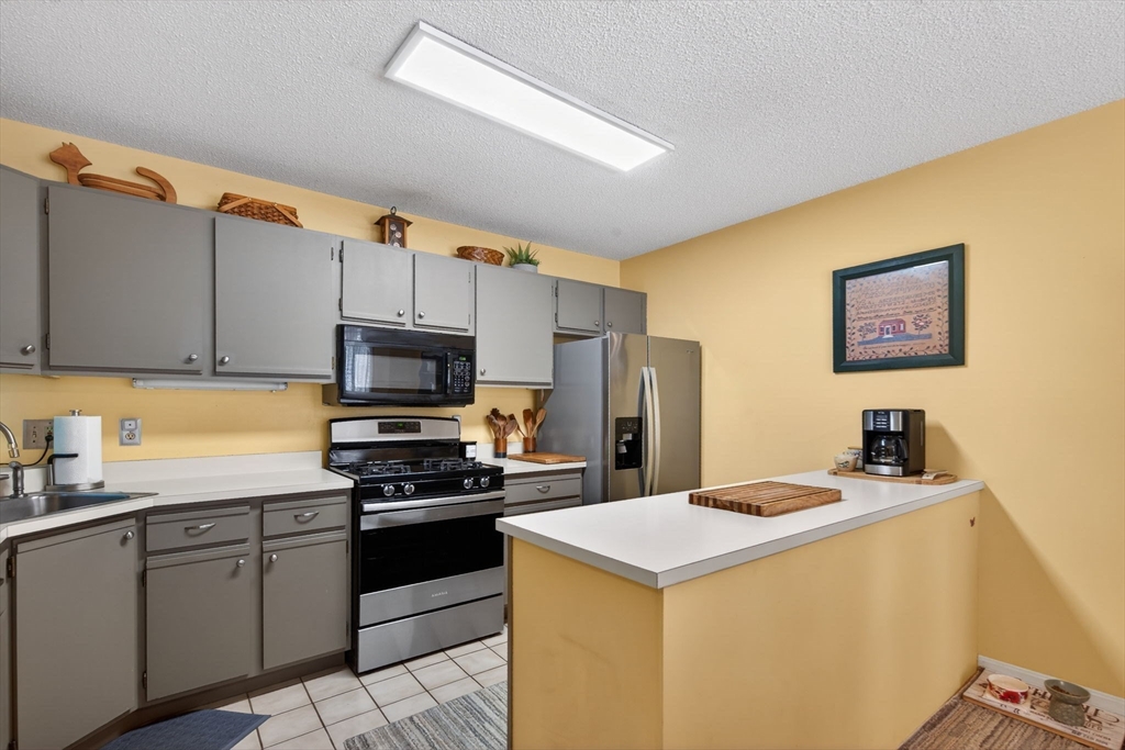 104 Johnson Road, Unit 1103 Chicopee, MA 01022 - Photo 7 of 42 a kitchen with a sink a stove and refrigerator