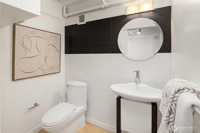 a bathroom with a toilet a sink and mirror