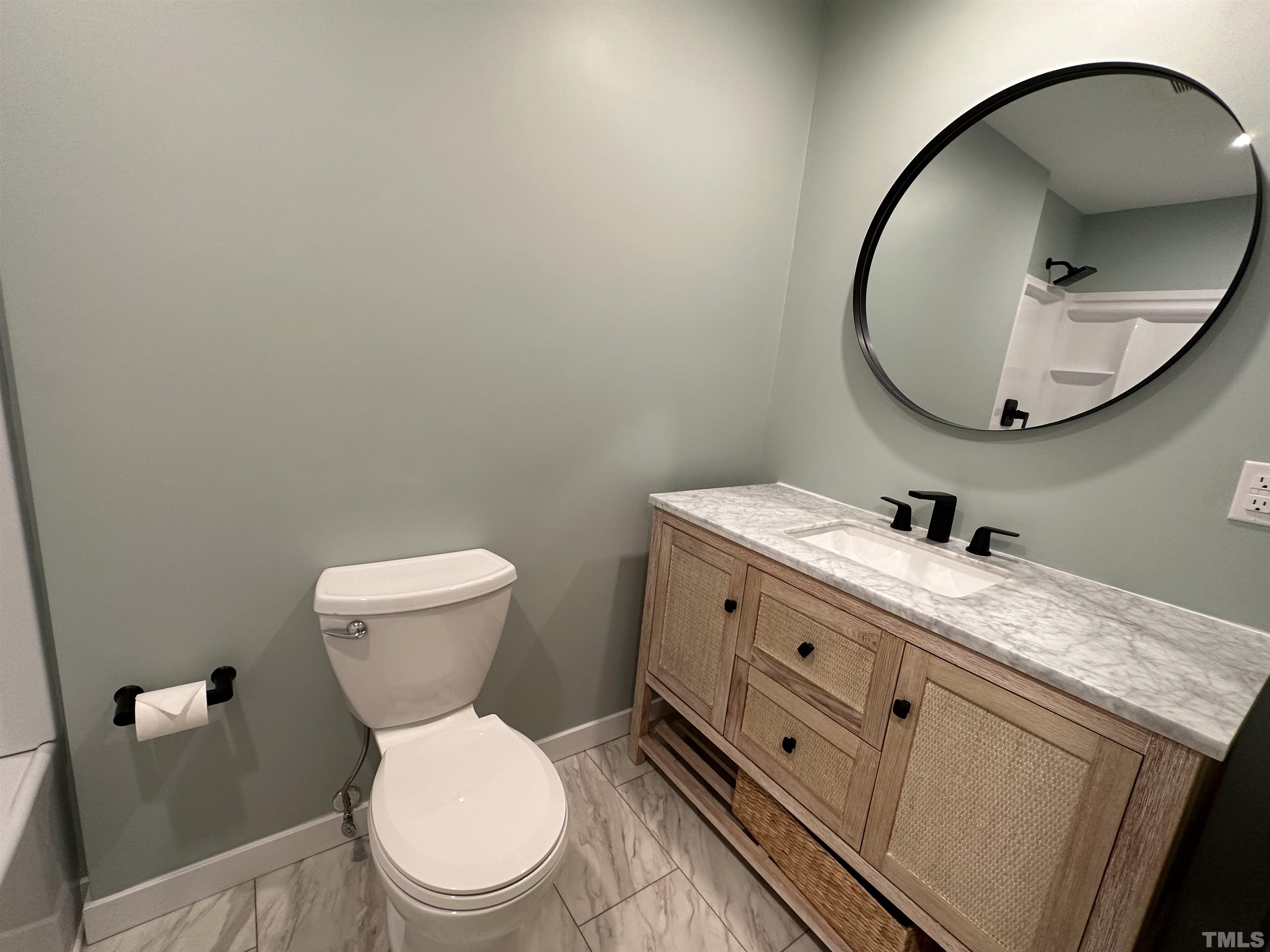 8904 Ransdell Road Raleigh, NC 27603 - Photo 14 of 23 a bathroom with a toilet a sink and mirror