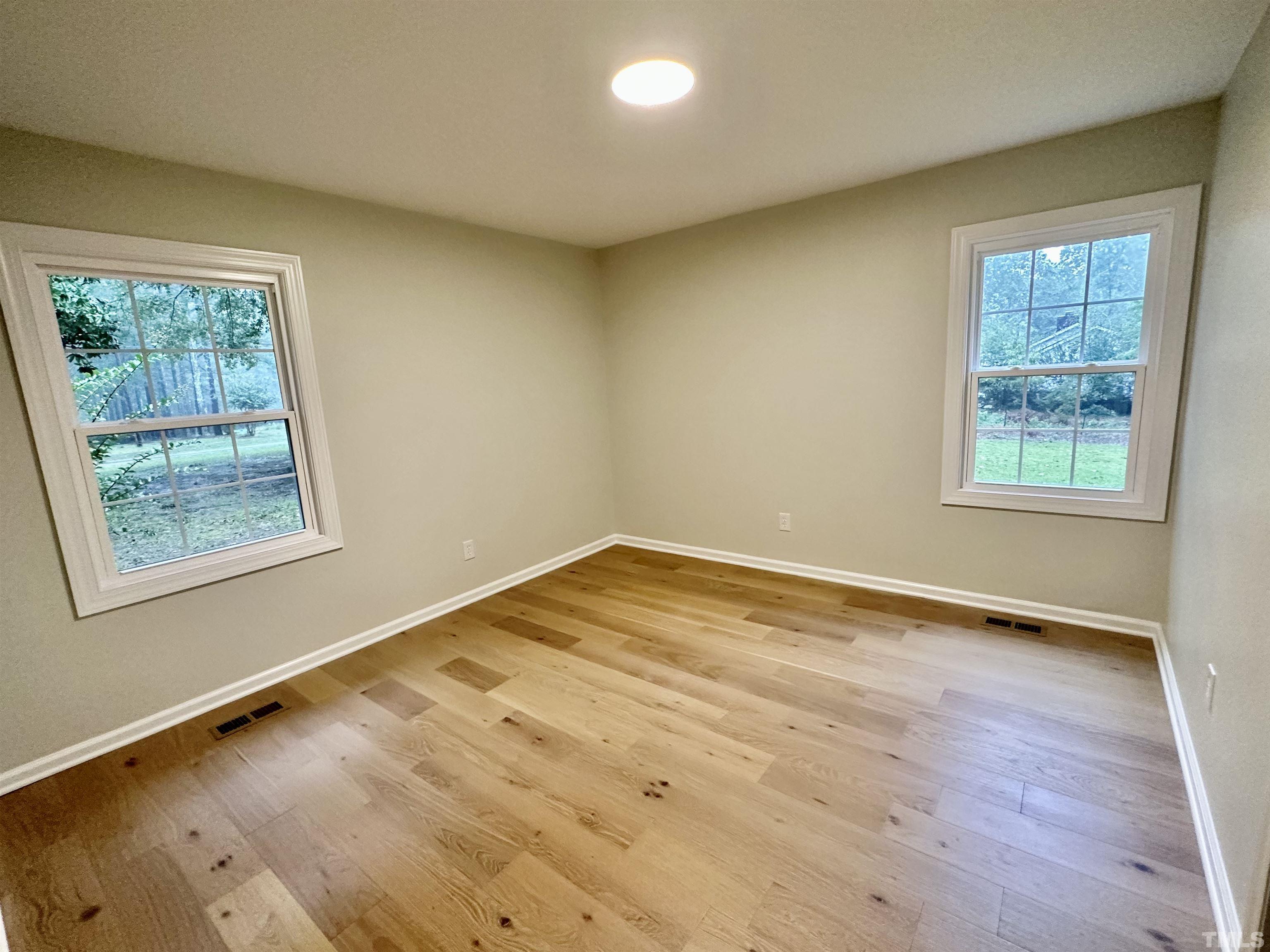 8904 Ransdell Road Raleigh, NC 27603 - Photo 16 of 23 a view of an empty room with wooden floor and a window