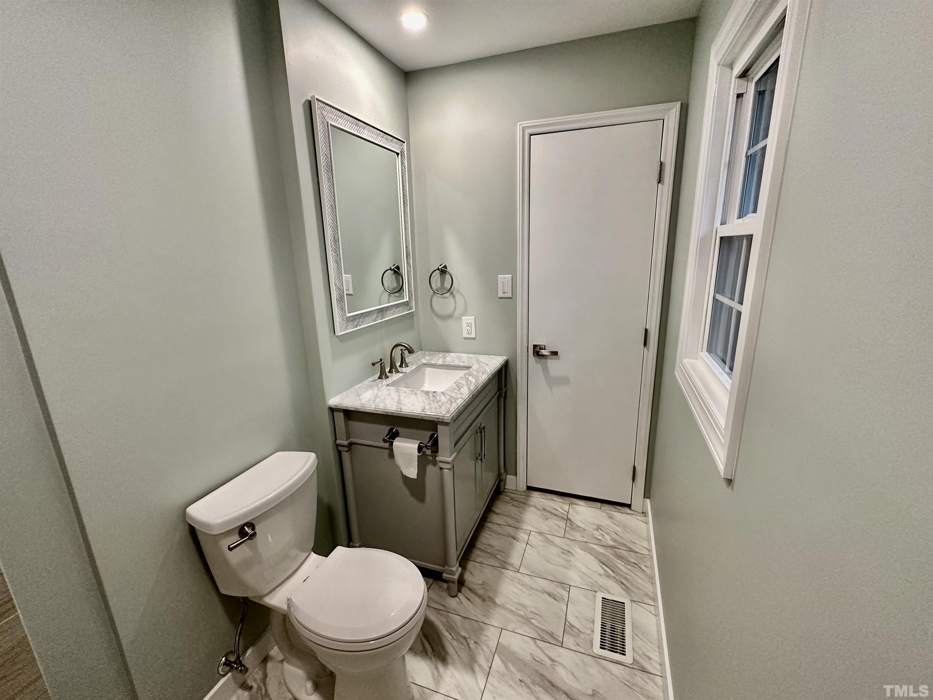 8904 Ransdell Road Raleigh, NC 27603 - Photo 20 of 23 a bathroom with a toilet sink and mirror
