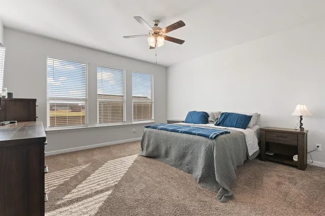 a spacious bedroom with a bed and a window