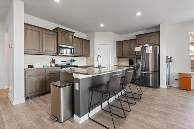 a kitchen with a sink cabinets and wooden floor