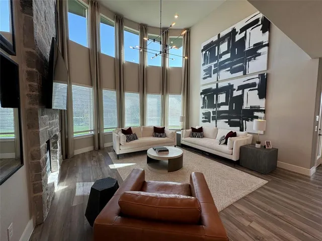 a living room with furniture kitchen view and a chandelier
