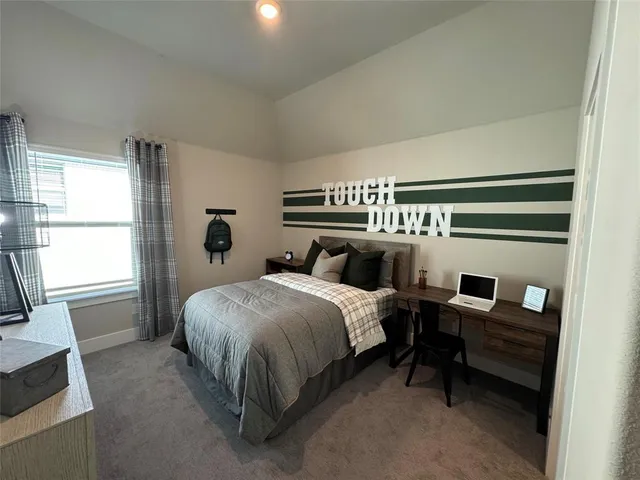 a bedroom with a bed and a flat tv screen on the dresser