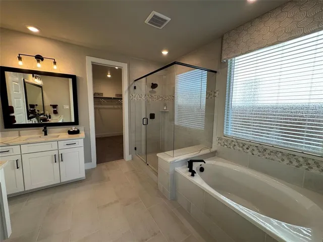 a spacious bedroom with a large bed and a chandelier