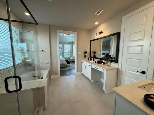 a bathroom with a double vanity sink mirror and shower