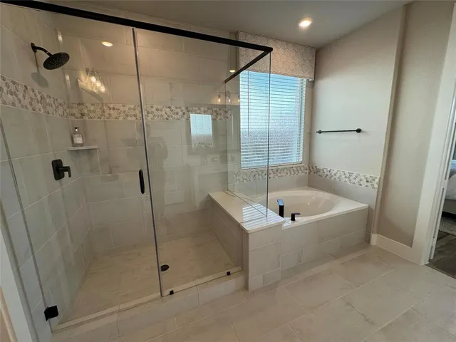 a spacious bathroom with a tub shower a sink and mirror