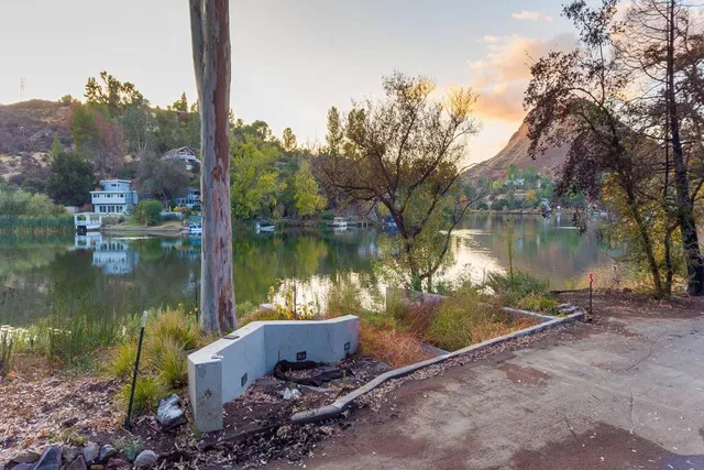 a body of water with a tree in the background
