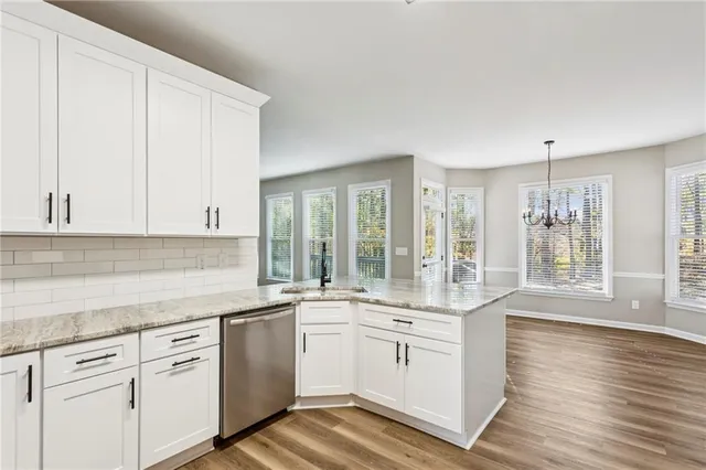a view of an empty room with a window and chandelier