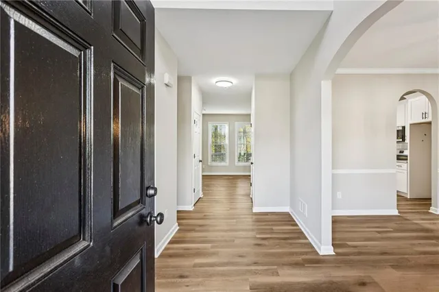 a view of a hallway with wooden floor and staircase
