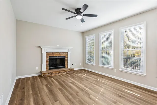 a view of an empty room with a window and fireplace