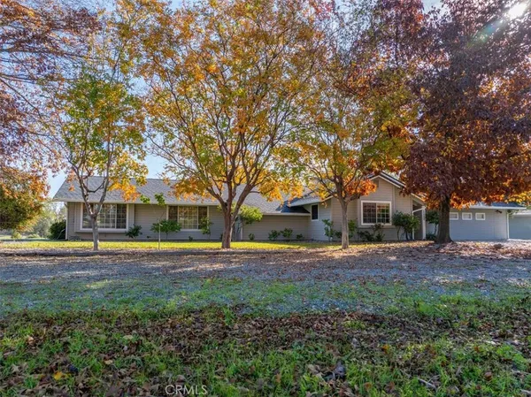 a front view of a house with a yard and trees